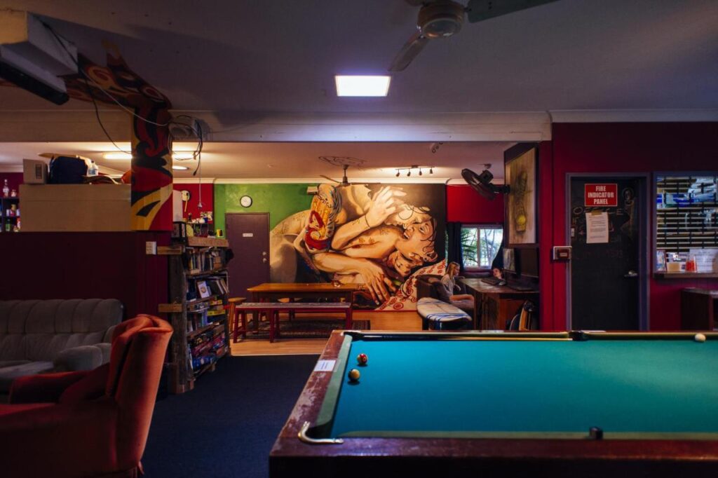 Entertainment room with pool table and spaces to sit to watch movies at the Beachside Backpackers