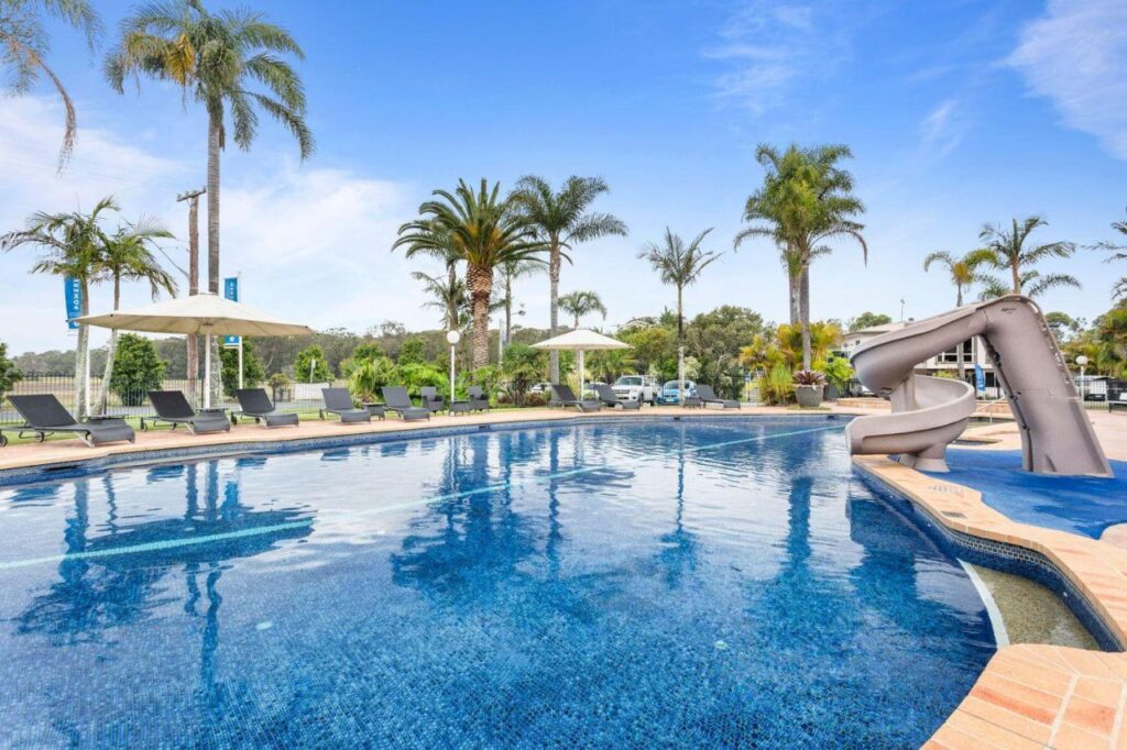 A super tranquil swimming pool with the bluest of water and palm trees in the background at Mountain View Resort