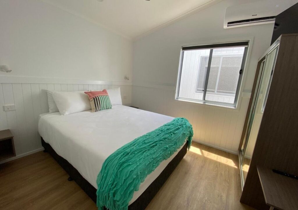 A confortable queen size bed located in on of the cabins at Nobby Beach Holiday Village