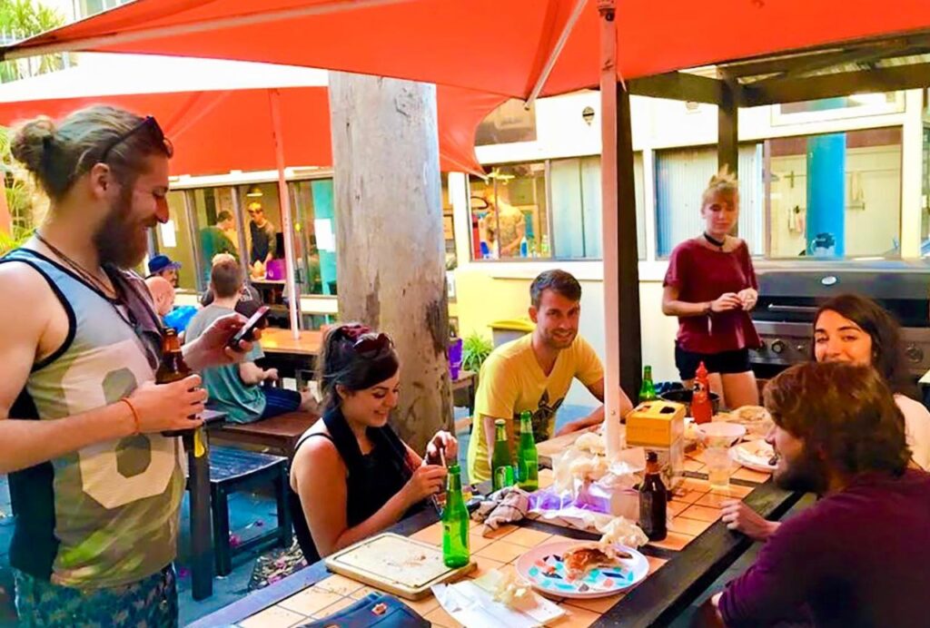 Travellers socialising in the outdoor garden at Original Backpackers