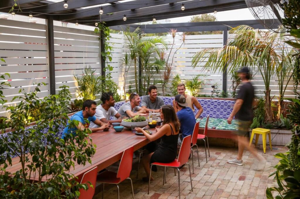 Travellers socialising and having dinner in the BBQ area at the Spinners Backpackers