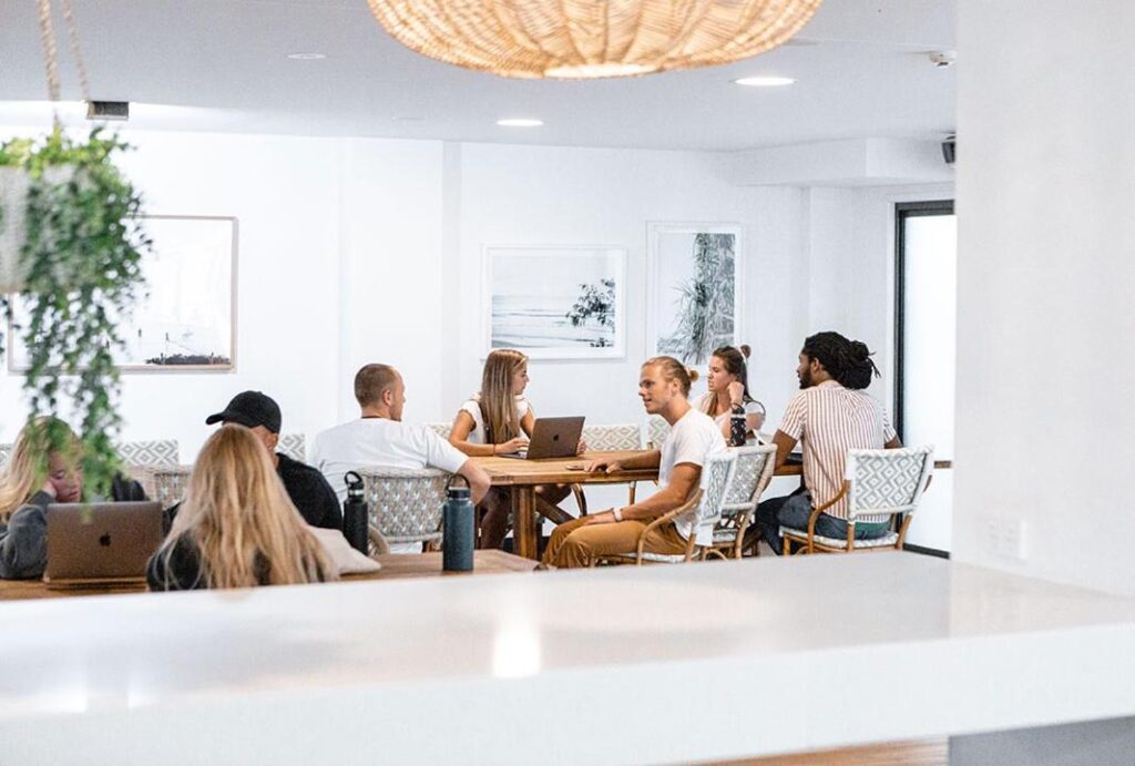 Guests relaxing and socialising on the dining room at The Surf House Byron Bay