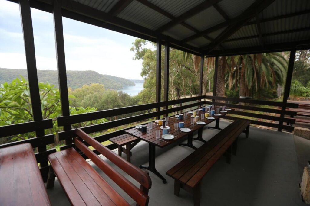 Terrace area over looking the trees with water views at YHA Pittwater Eco Sydney