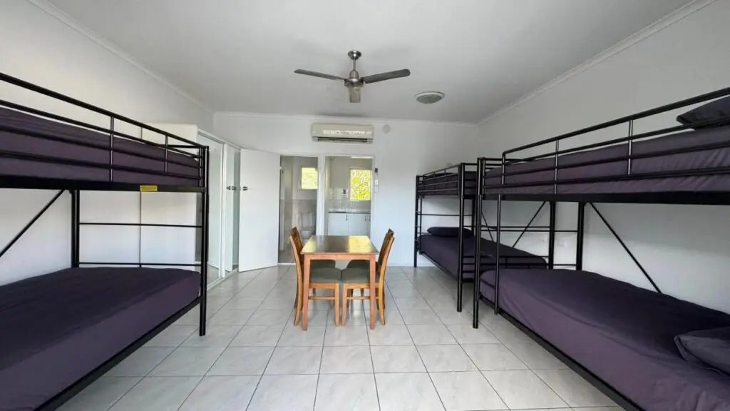 A six bed dormitory with sheets and a shared bathroom for guests staying at Accom KC's