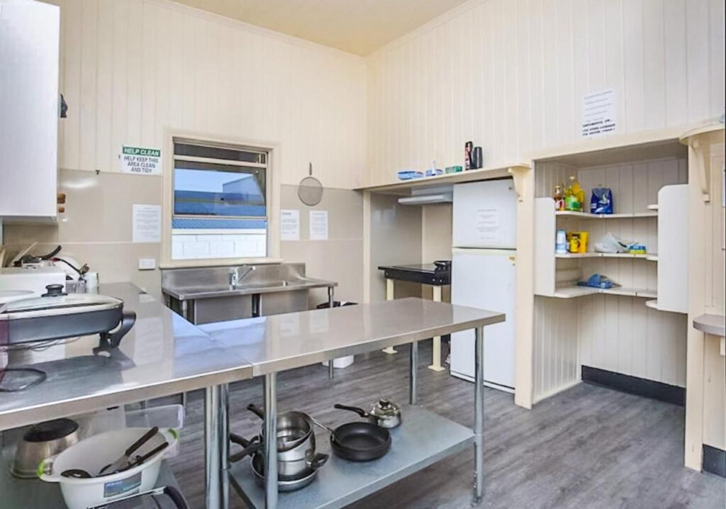 The shared kitched with stainless steel bench tops and full amenities for guests at Bunk Inn Hostel