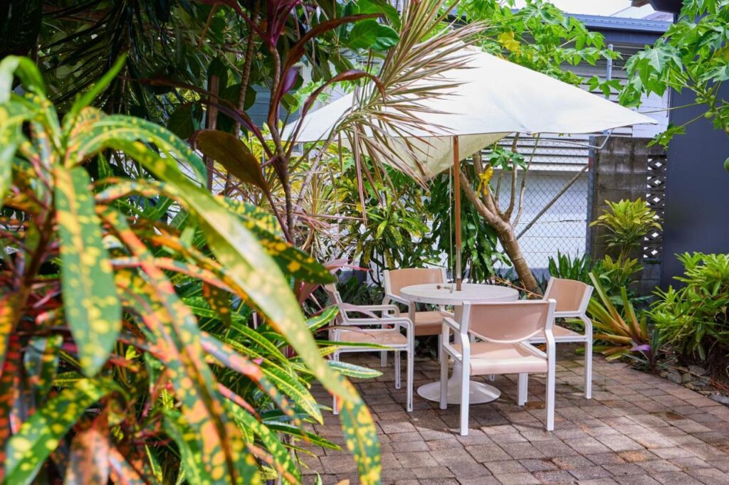 Beautiful gardens and tabels and chairs to unwind after a long day exploring Cairns at Cairns City Backpackers Hostel