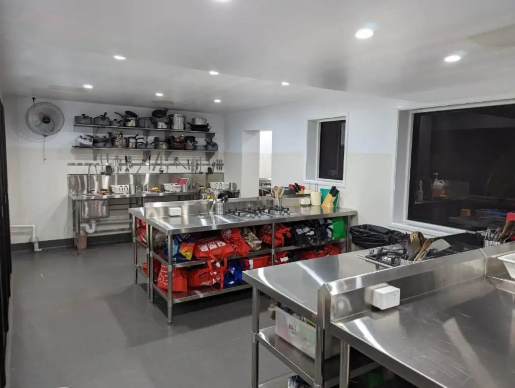 Kitchen with stainless steel bench tops and plenty of space for cooking in a shared kitchen at Somewhere To Stay Backpackers