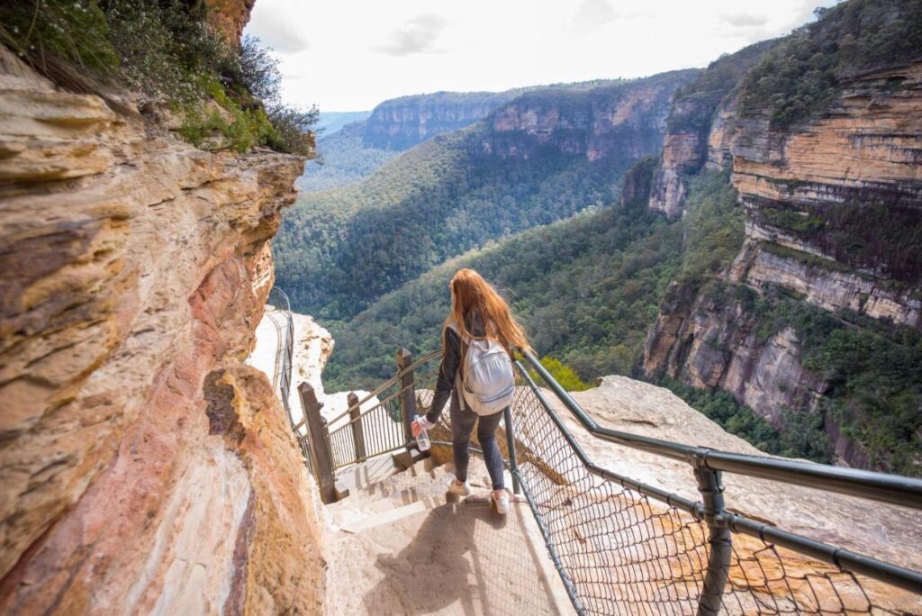 A back packer exploring the Blue Mountains on a hike or bush walk along the cliff edges. Yes, there are safety rales along the track near YHA Blue Mountains Katoomba