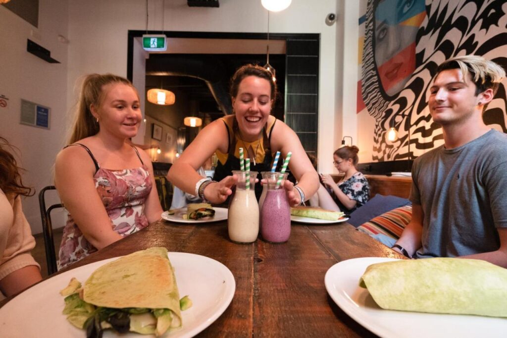 A communal dining area with travellers getting ready to eat at YHA Melbourne Central