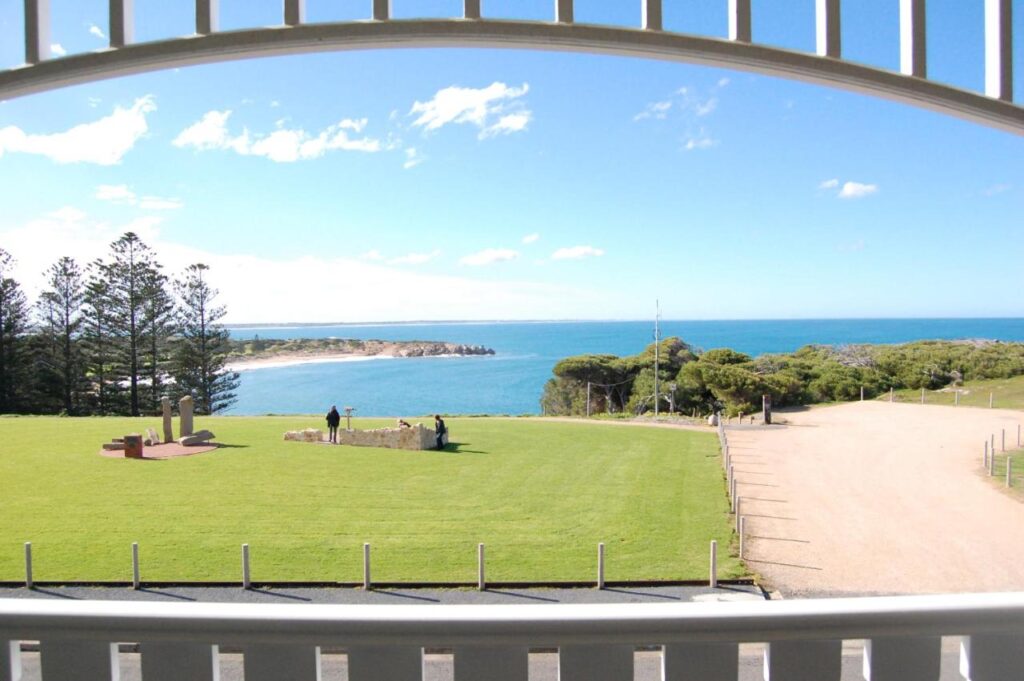 View directly out to the bay. Green grass and a vast ocean at YHA Port Elliot Beach House